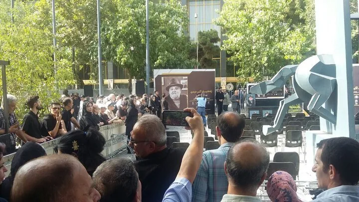 تنها زنی که در کنار مردان زیر تابوت اکبر عبدی رفت | هجوم جمعیت را ببینید