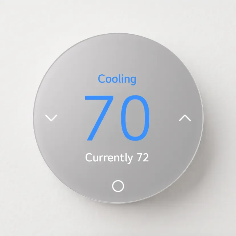 نمای یک ترموستات هوشمند دایره‌ای‌شکل با بدنه خاکستری‌رنگ که عبارت «Cooling» و عدد دمای «۷۰» به رنگ آبی در مرکز آن درج شده است.