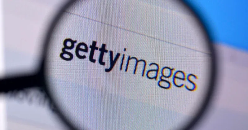 تصویر بزرگ‌نمایی‌شده از لوگوی «gettyimages» روی یک صفحه نمایش که از زیر ذره‌بین دیده می‌شود.