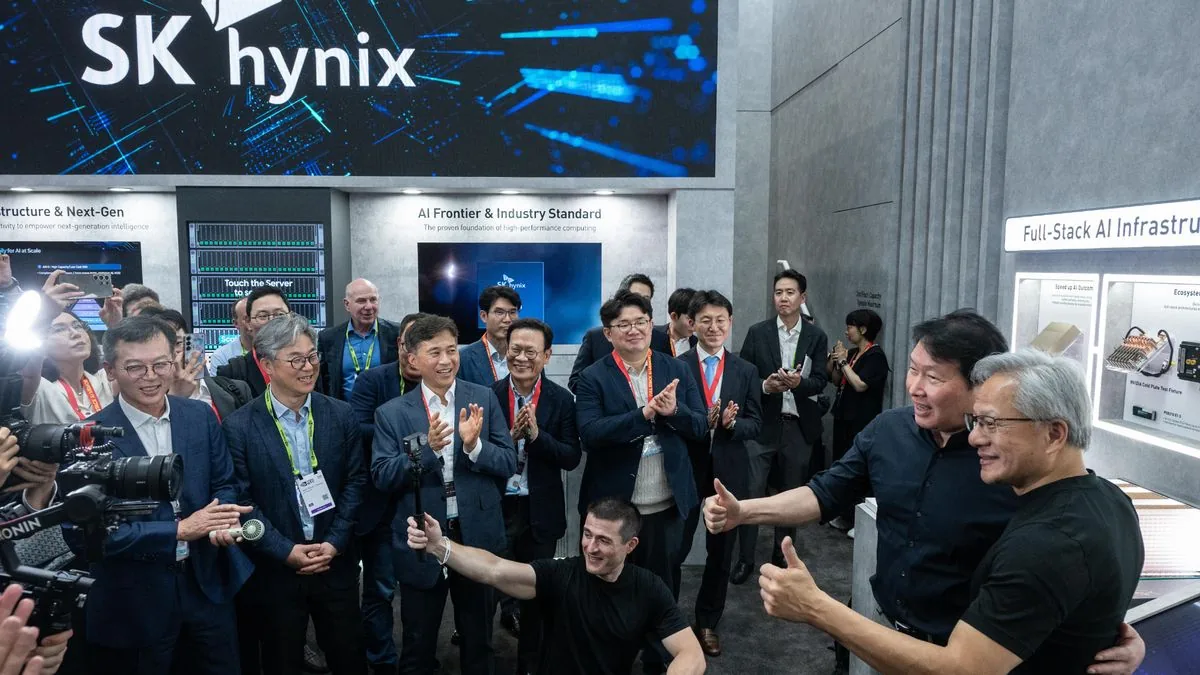 تصویری از مدیران شرکت SK hynix و انویدیا به همراه مدیرعامل انویدیا در یک نمایشگاه فناوری با پس‌زمینه غرفه و نمایشگرهای دیجیتال.