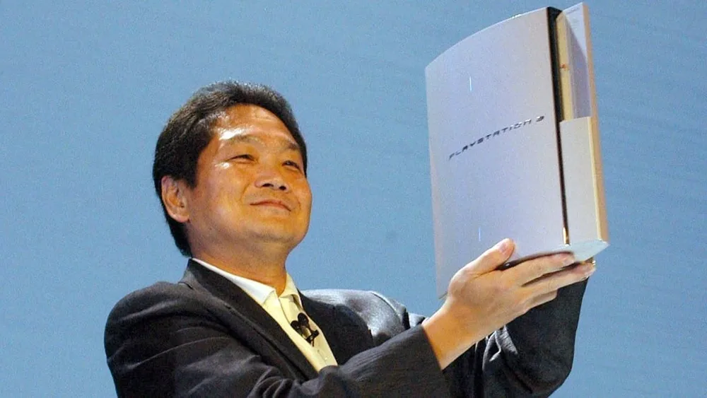 کِن کوتاراگی، خالق پلی‌استیشن، در حال نگه داشتن و معرفی کنسول پلی‌استیشن ۳ (PlayStation 3) در یکی از رویدادهای رسمی.