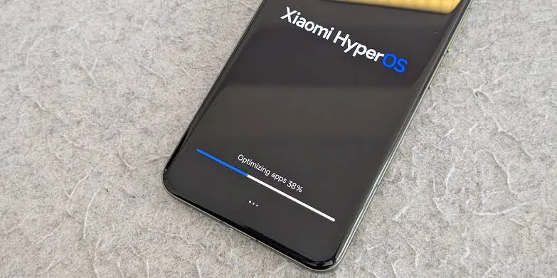 نمای نزدیک از نمایشگر یک گوشی شیائومی با سیستم‌عامل Xiaomi HyperOS در حال بهینه‌سازی اپلیکیشن‌ها و نوار درصد پیشرفت.